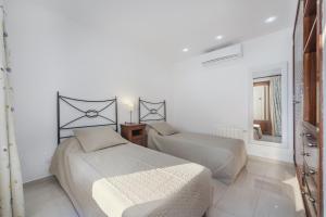 a bedroom with two beds and a mirror at Apartment Vistamar IV in Port de Pollensa
