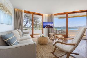 een woonkamer met een bank en een stoel bij El Faro in Port de Pollença