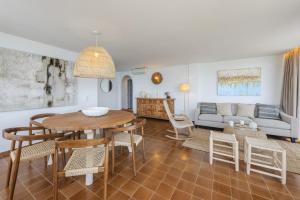een woonkamer met een tafel, stoelen en een bank bij El Faro in Port de Pollença