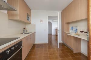 een keuken met houten kasten en een tegelvloer bij El Faro in Port de Pollença +9 foto's