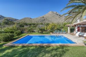 a swimming pool in a yard with mountains in the background at Villa Can Deyá in Port de Pollensa