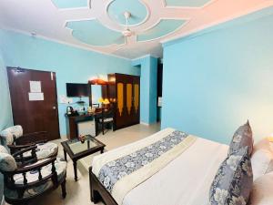 sypialnia z niebieskimi ścianami, łóżkiem i kanapą w obiekcie Hotel Paras - Karol Bagh Delhi w Nowym Delhi