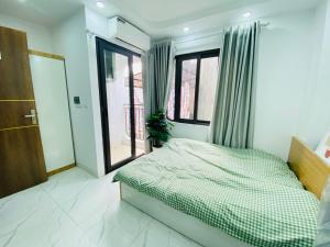 een slaapkamer met een bed en een groot raam bij Nhà 40C Hoàng Ngân in Hanoi