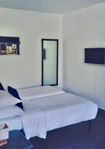 a bedroom with two beds and a tv on the wall at Poisson Rouge in Bonifacio