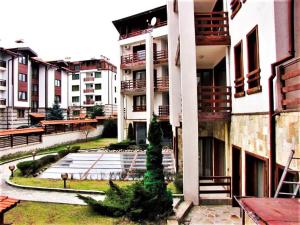 an apartment building with a tree in the courtyard at Predela 1 - Studio 04 near Bansko Ski Lift in Bansko