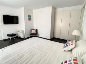 a bedroom with a large white bed and a flat screen tv at Appartements de Standing Cannes Centre in Cannes +48 photos