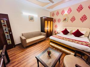 Pokój hotelowy z łóżkiem, kanapą i stołem w obiekcie Hotel Paras - Karol Bagh Delhi w Nowym Delhi