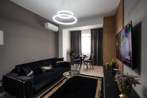 a living room with a black couch and a table at Blvd Ivory Pipera ap.62B in Bucharest