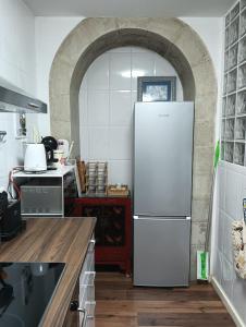 a white refrigerator in a kitchen with an archway at ChâtEscos - Estudio en Château in Escos