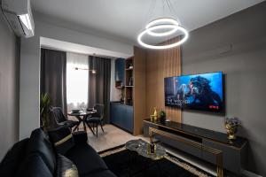 a living room with a couch and a tv on a wall at Blvd Ivory Pipera ap.62B in Bucharest