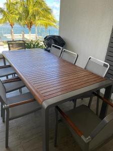 a wooden table and chairs with a view of the ocean at Tropics retreat in Rivière Noire
