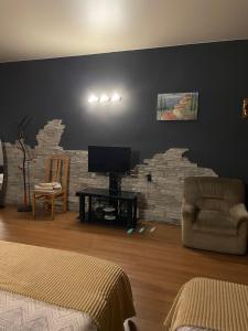 a living room with a tv and a brick wall at Hotel ERA in Tbilisi City