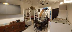 Il comprend une cuisine et un salon avec une table et des chaises. dans l'établissement Alinda House Naukuchiatal by THE GHAUR, à Bhimtal