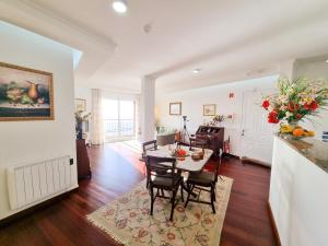 a dining room and living room with a table and chairs at Casa da Ladeira in Fajã da Ovelha