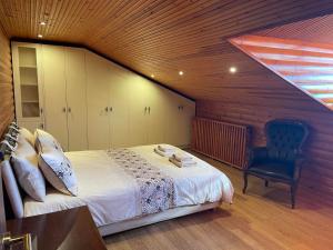 1 dormitorio con 1 cama y 1 silla en el ático en SOFIA APARTMENTS, en Tesalónica