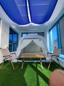 Zelt in einem Zimmer mit 2 Stühlen in der Unterkunft Yeosu Blueara Premium Pool Villa in Yeosu