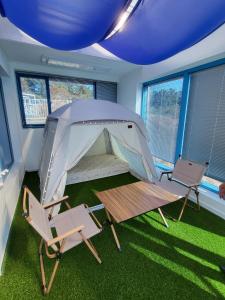 a room with a tent and two chairs and a table at Yeosu Blueara Premium Pool Villa in Yeosu