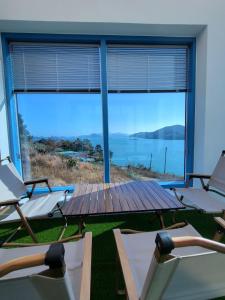 een kamer met stoelen, een tafel en een groot raam bij Yeosu Blueara Premium Pool Villa in Yeosu