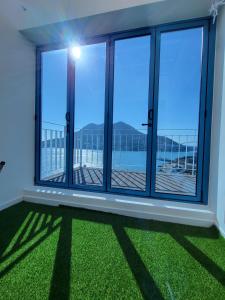Zimmer mit großen Fenstern und grünem Gras in der Unterkunft Yeosu Blueara Premium Pool Villa in Yeosu