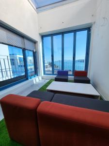 a room with a couch and a table and windows at Yeosu Blueara Premium Pool Villa in Yeosu