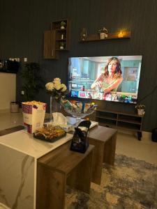 a living room with a flat screen tv and a table at شقة فاخرة (مدخل خاص - دخول ذاتي) in Riyadh