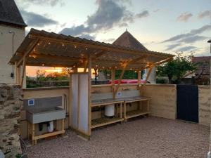 a wooden pergola with a table and a bench at Minicamping Sous les Cloches in Terjat