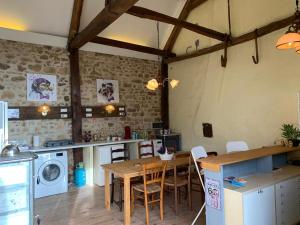 a kitchen with a table and a stove and a washer at Minicamping Sous les Cloches in Terjat