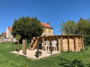 a wooden shed with two chairs in a yard at Minicamping Sous les Cloches in Terjat +5 photos
