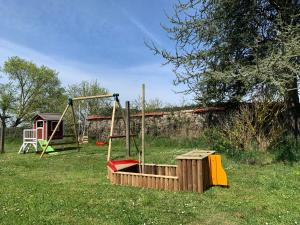 a park with a swing set and a playground at Minicamping Sous les Cloches in Terjat