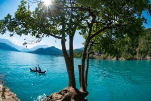 two people in a boat on a lake with trees at Minicamping Sous les Cloches in Terjat