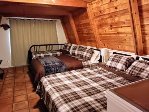 - une chambre avec 2 lits dans une cabane en rondins dans l'établissement Friar Tuck Cottage - Close to Williams, Flagstaff and the Grand Canyon, à Williams