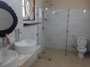 a bathroom with a shower and a sink and a toilet at Kijiji Beach Resort in Dar es Salaam
