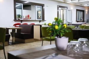 a restaurant with tables and chairs and a potted plant at B&B Il Cavaliere Tropea in Santa Domenica