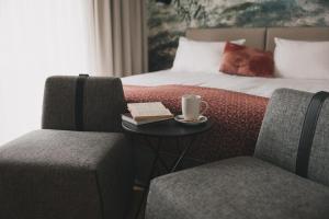 博希尼的住宿－Hotel Majerca，酒店客房配有一张带桌子和两把椅子的床。