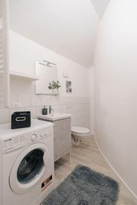 baño blanco con lavadora y lavamanos en Loft Fred - by Casêta, en Ancona