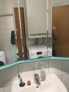 a person taking a picture of a mirror over a bathroom sink at Central in Dornbirn