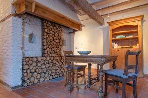 uma mesa e cadeiras num quarto com uma lareira de tijolos em Vakantiewoning De Luysmolen em Bocholt