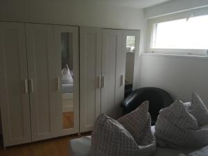 uma sala de estar com um armário e almofadas num sofá em Central em Dornbirn