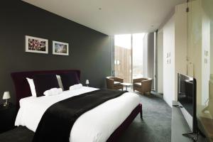 a bedroom with a large bed and a television at Terrazze in Kutchan