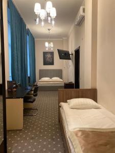 een hotelkamer met 2 bedden, een bureau en een slaapkamer bij MyLINE relax complex in Astana