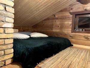 a bedroom with a bed in a log cabin at Kaimukas - namelis prie ežero keturiems in Dvarčėnai