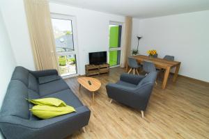 een woonkamer met een bank, stoelen en een tafel bij Ferienweingut Ulrike Thul in Leiwen