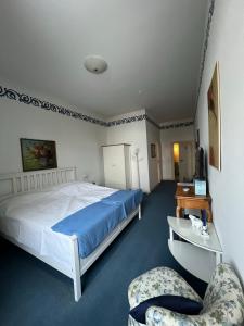 1 dormitorio con 1 cama grande y 2 sillas en Schloss Rössing - Messezimmer in historischem Ambiente, en Nordstemmen