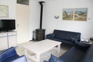 a living room with a couch and a table and a stove at Crox Houcke 65 in Nieuwvliet