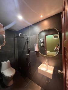 a bathroom with a mirror and a toilet and a sink at Meow Hotel & Cafe 2 in Ho Chi Minh City
