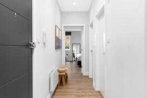 a hallway of a house with white walls and wooden floors at Stunning and Extremely spacious 1bed flat in Tooting in London