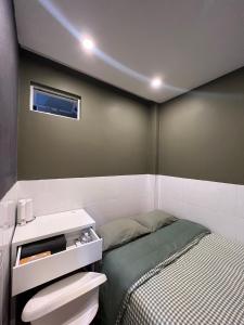 a small bedroom with a bed and a sink at Meow Hotel & Cafe 2 in Ho Chi Minh City