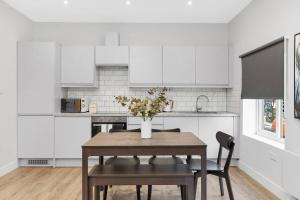 a kitchen with a table with a vase of flowers on it at Stunning and Extremely spacious 1bed flat in Tooting in London