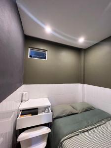 a small bedroom with a bed and a sink at Meow Hotel & Cafe 2 in Ho Chi Minh City