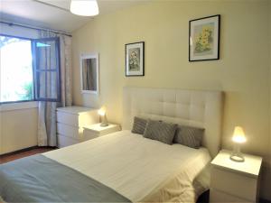 a bedroom with a white bed with two night stands at V2 Vilar Jardim Piscina wifi in Quarteira +62 photos